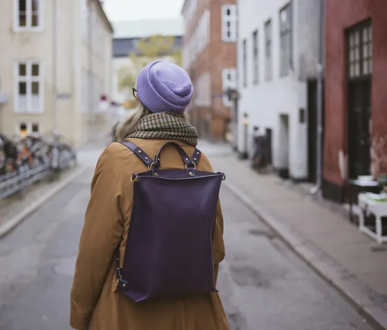 Young professional with a backpack walking along a European street